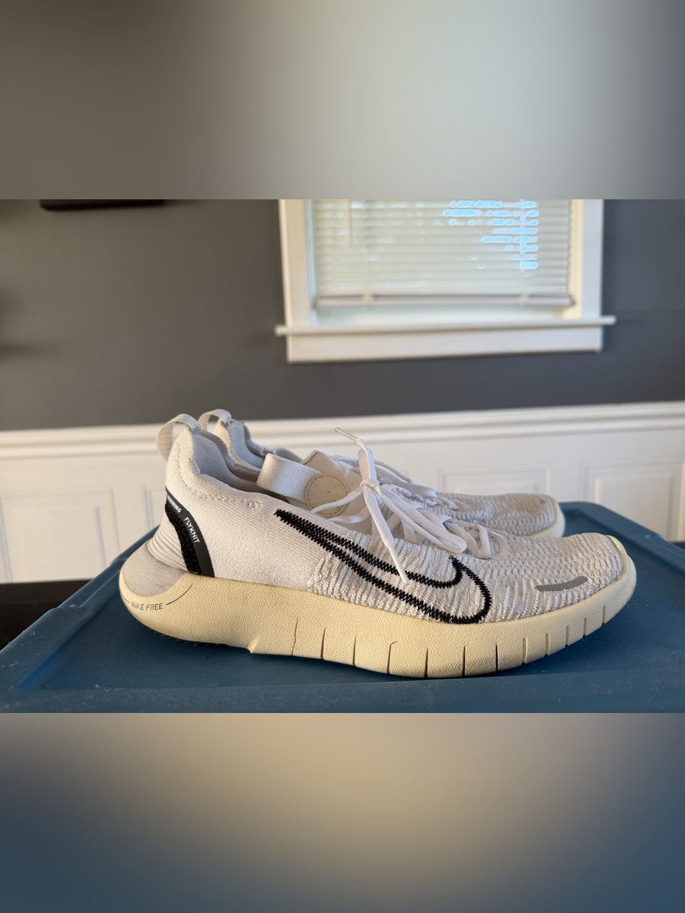 Nike White Flyknit Athletic Sneakers with Black Swoosh and Cream Sole